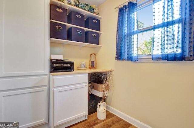 washroom with baseboards and wood finished floors