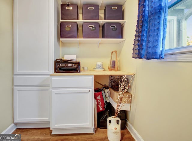 interior space featuring baseboards and wood finished floors
