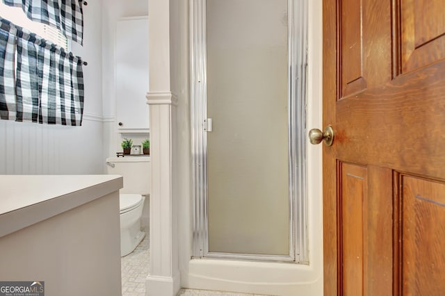 bathroom featuring toilet and a stall shower