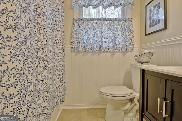 bathroom with vanity, wainscoting, tile patterned floors, and toilet