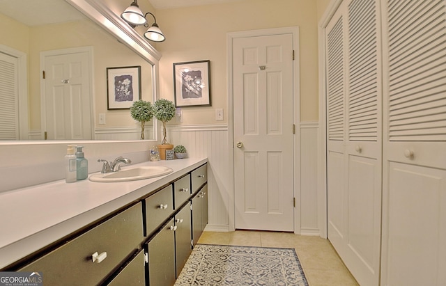 bathroom with vanity, tile patterned floors, a closet, and a wainscoted wall