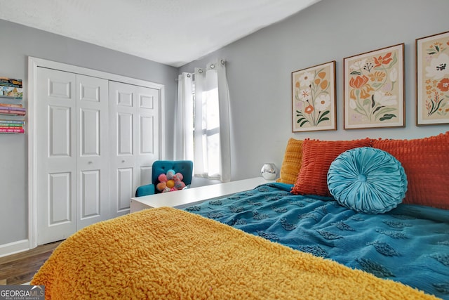 bedroom with a closet, baseboards, and wood finished floors
