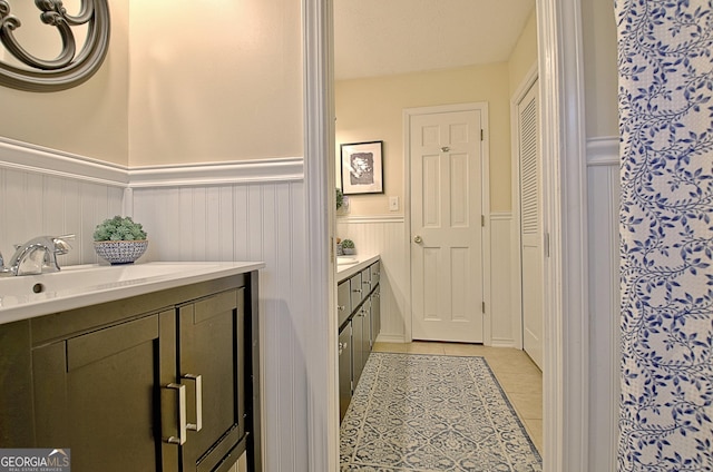 bathroom featuring vanity, wainscoting, and tile patterned floors
