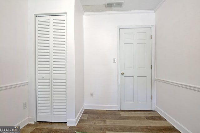 hall featuring visible vents, baseboards, and wood finished floors