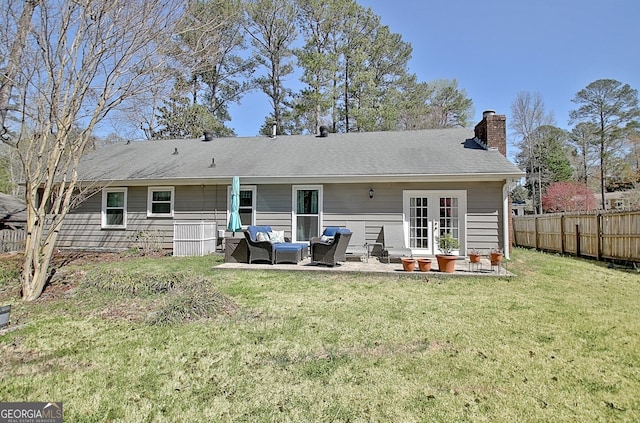 rear view of property featuring fence, an outdoor hangout area, a chimney, a patio area, and a yard