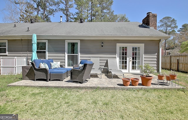 back of house featuring a chimney, french doors, a lawn, fence, and an outdoor hangout area