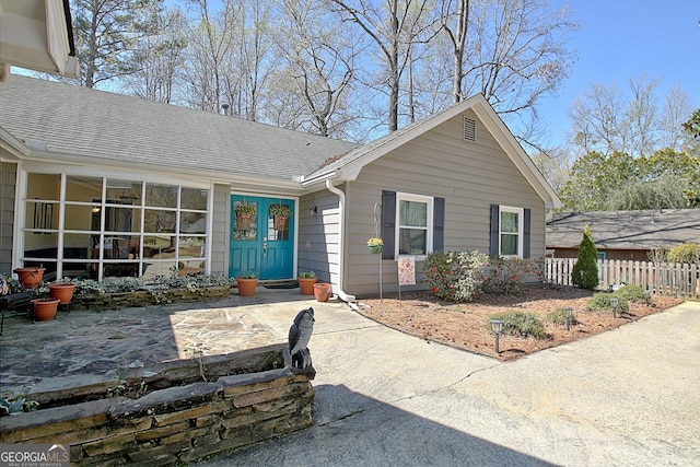 view of front facade with fence and a shingled roof