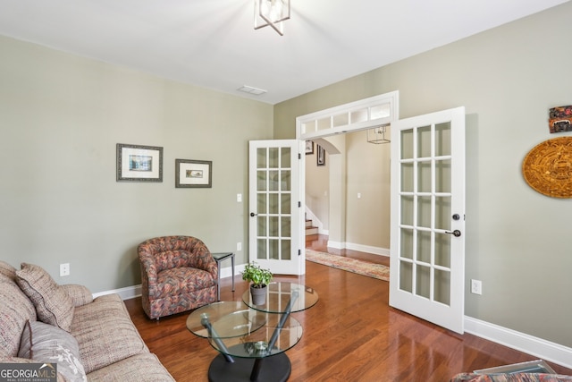 living room with baseboards, french doors, stairs, and wood finished floors