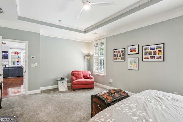 carpeted bedroom with crown molding, a ceiling fan, a raised ceiling, and baseboards