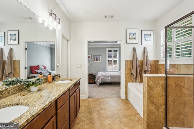bathroom with visible vents, a sink, ensuite bathroom, and a healthy amount of sunlight