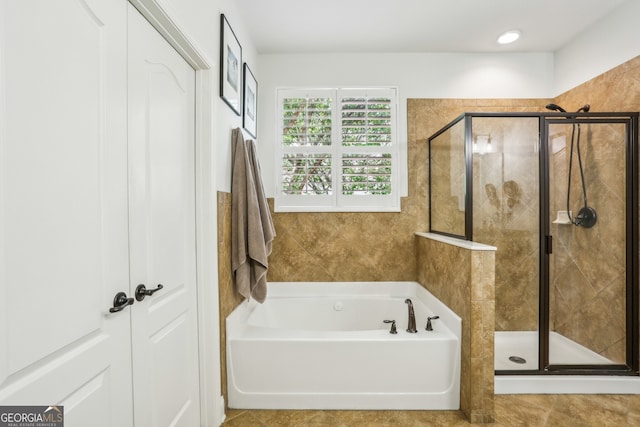 bathroom with a stall shower and a garden tub