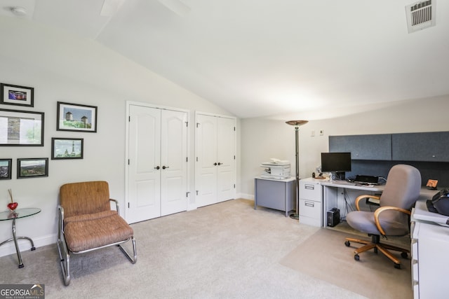 office area featuring visible vents, baseboards, vaulted ceiling, and light colored carpet