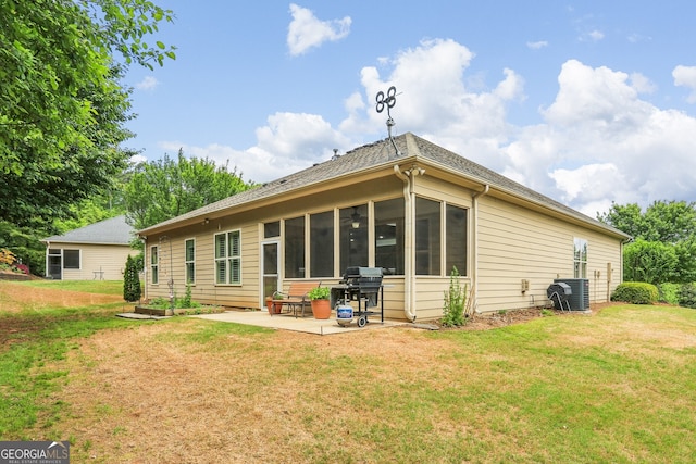 rear view of house featuring a sunroom, a yard, and a patio area