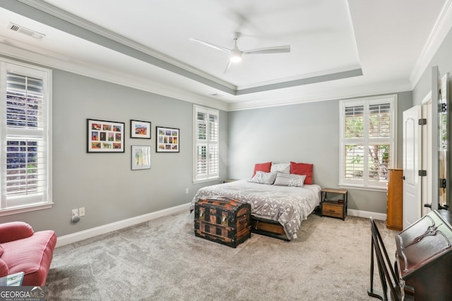 carpeted bedroom featuring crown molding, visible vents, baseboards, ceiling fan, and a tray ceiling