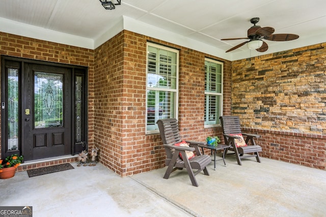 doorway to property with a porch, brick siding, and ceiling fan