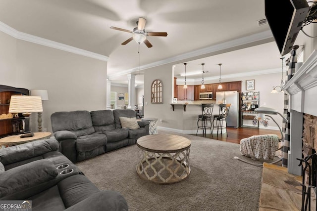 1929 Windstone Pl, Winder, GA 30680 - living area with ceiling fan, decorative columns, crown molding, baseboards, and a fireplace with raised hearth