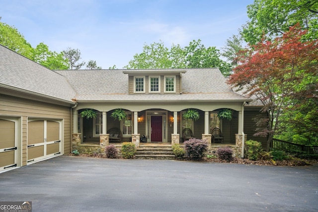 201 Wilderness Knl, Big Canoe, GA 30143 - view of front of house with a porch, driveway, an attached garage, a shingled roof, and stone siding
