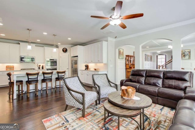1040 Peyton View Ct, Alpharetta, GA 30004 - living area with crown molding, arched walkways, a ceiling fan, and dark wood-style flooring