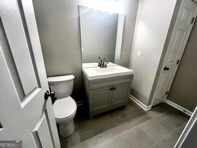 bathroom with vanity, tile patterned floors, and toilet