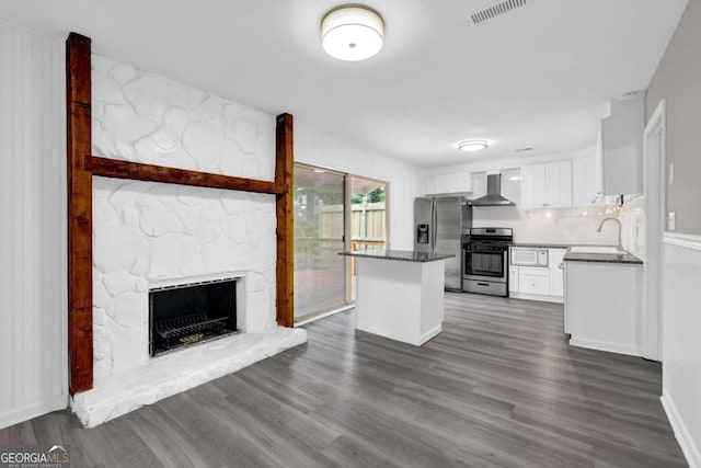 2551 Park Rd SE, Smyrna, GA 30080 - kitchen featuring stainless steel appliances, dark countertops, white cabinetry, and wall chimney exhaust hood