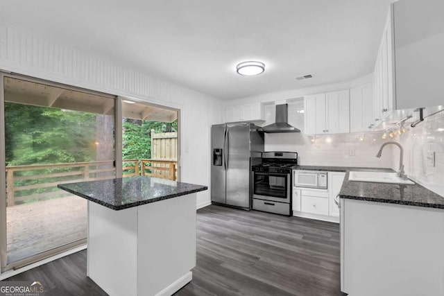 2551 Park Rd SE, Smyrna, GA 30080 - kitchen with white cabinets, appliances with stainless steel finishes, a sink, wall chimney exhaust hood, and decorative backsplash