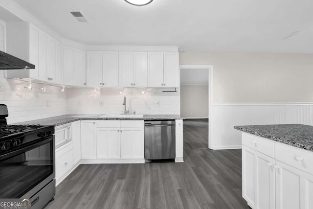 2551 Park Rd SE, Smyrna, GA 30080 - kitchen featuring wall chimney range hood, range with gas cooktop, stainless steel dishwasher, a sink, and white cabinets