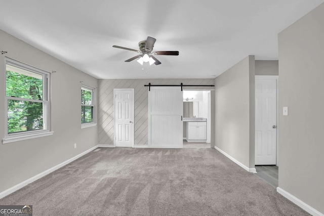 2551 Park Rd SE, Smyrna, GA 30080 - unfurnished bedroom featuring carpet floors, a barn door, baseboards, and ceiling fan