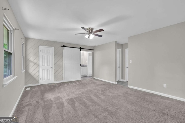 2551 Park Rd SE, Smyrna, GA 30080 - unfurnished bedroom with a barn door, carpet, a ceiling fan, baseboards, and visible vents
