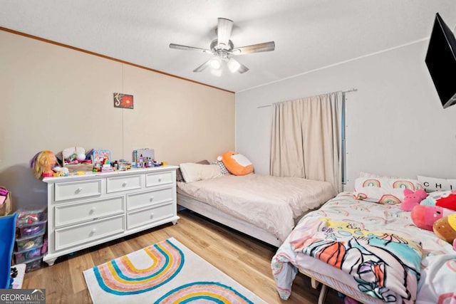 bedroom with ceiling fan, ornamental molding, and light wood finished floors