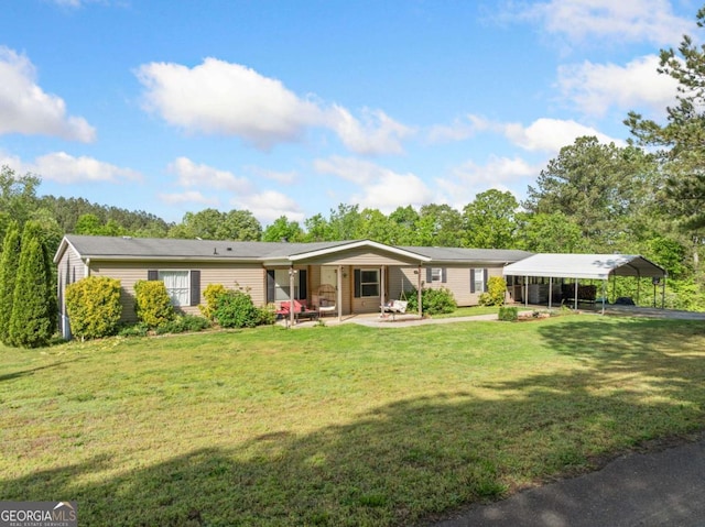 back of house featuring a lawn and a detached carport