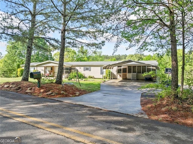 1575 Davis Rd W, Fairmount, GA 30139 - manufactured / mobile home with concrete driveway, a carport, a sunroom, and a front yard