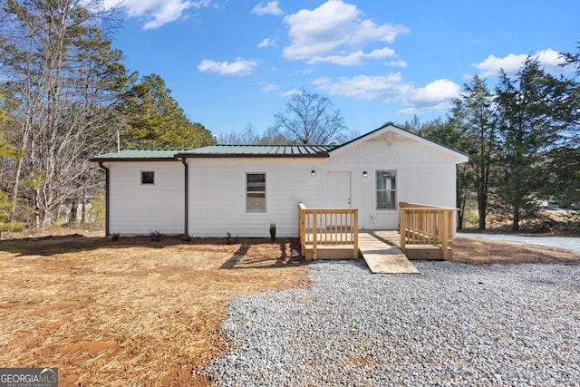 rear view of house with metal roof and a wooden deck
