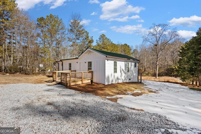 view of home's exterior featuring crawl space, a deck, and metal roof