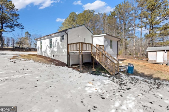 rear view of property with an outdoor structure and a shed
