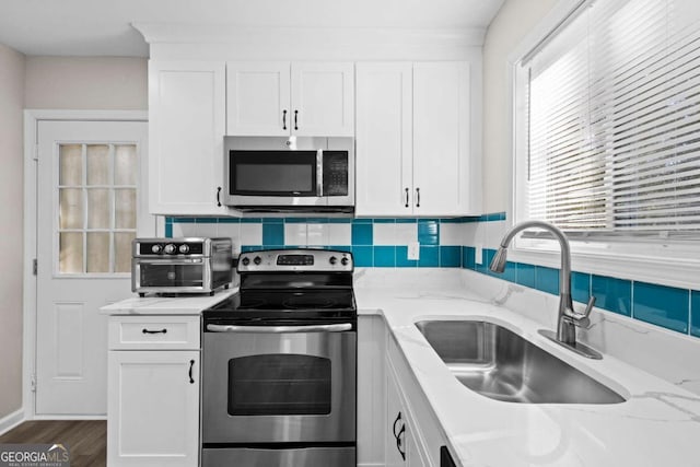 kitchen featuring a sink, white cabinets, and stainless steel appliances