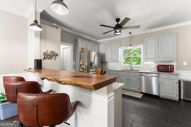 1536 Enota Ave NE, Gainesville, GA 30501 - kitchen featuring stainless steel appliances, a peninsula, a kitchen breakfast bar, a ceiling fan, and crown molding