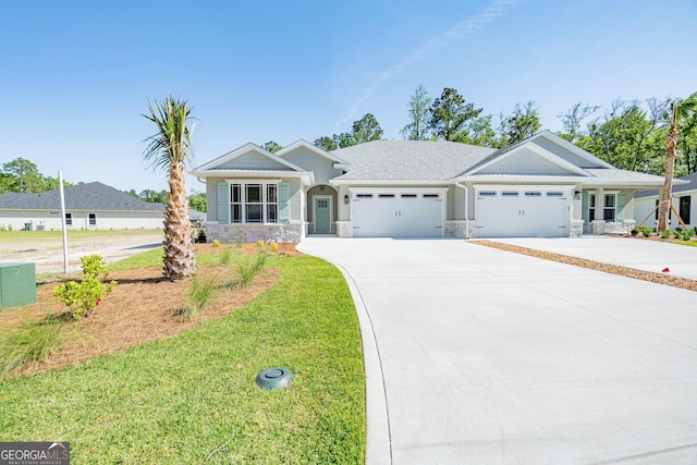 view of front facade featuring a front yard, an attached garage, driveway, and stone siding