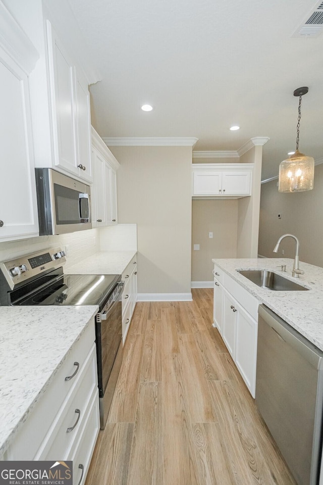 kitchen with crown molding, stainless steel appliances, white cabinets, and a sink
