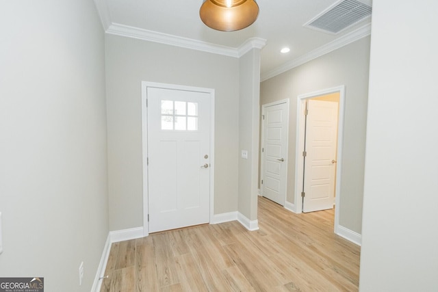 entryway featuring visible vents, light wood-style flooring, crown molding, and baseboards