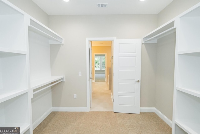 spacious closet featuring light colored carpet and visible vents