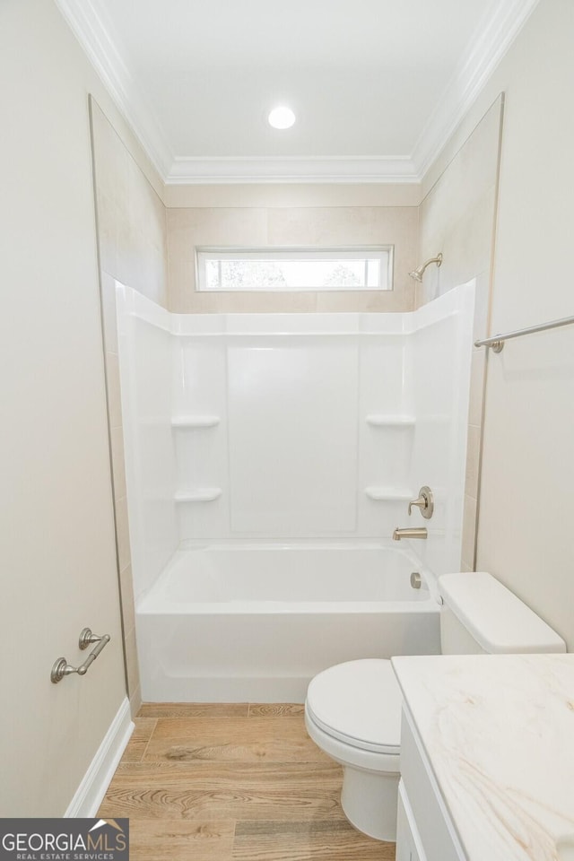 bathroom with toilet, ornamental molding, shower / bathing tub combination, and wood finished floors