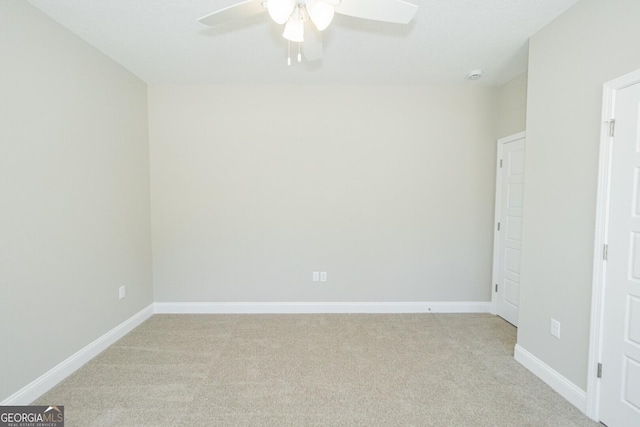 unfurnished room with baseboards, ceiling fan, and light carpet