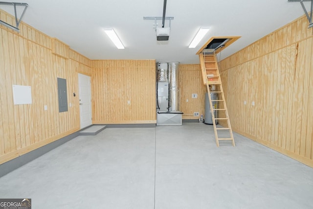 interior space with wooden walls, a garage door opener, gas water heater, and electric panel