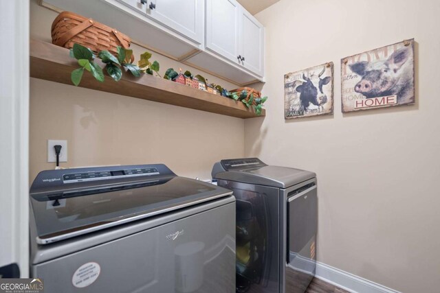 laundry room featuring baseboards, cabinet space, and independent washer and dryer