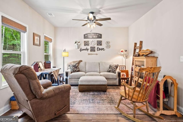 living room with baseboards, ceiling fan, visible vents, and wood finished floors