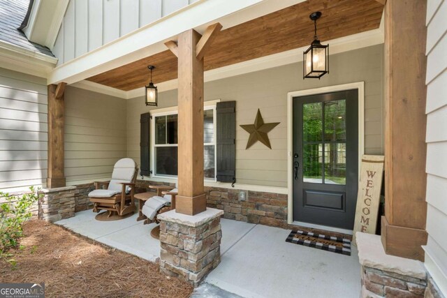 doorway to property with board and batten siding and covered porch