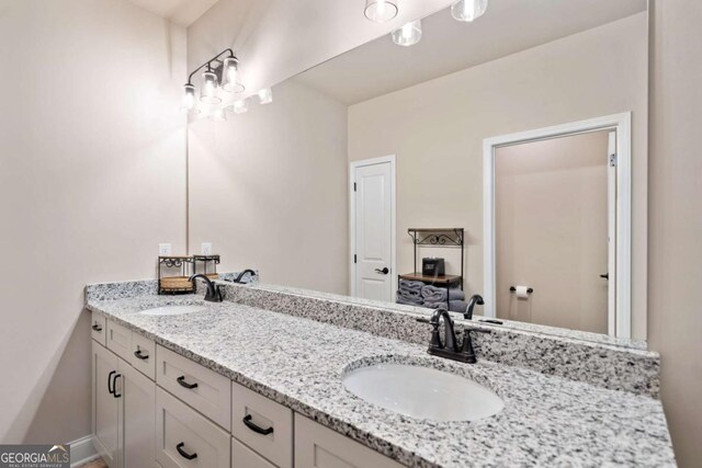 full bath with a sink, baseboards, and double vanity