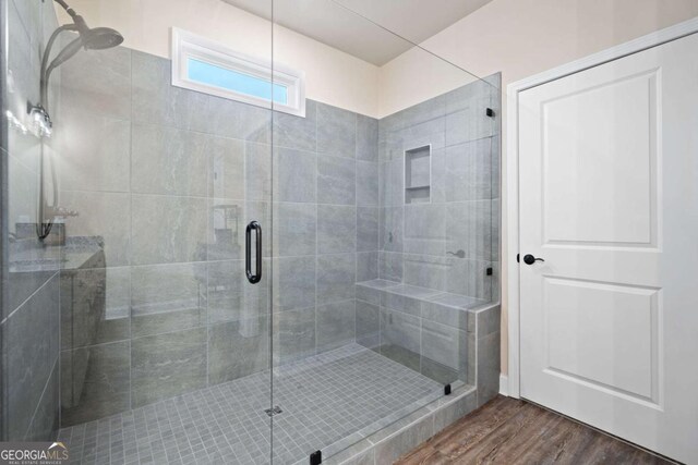 bathroom with a stall shower and wood finished floors