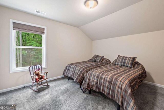 bedroom featuring baseboards, carpet flooring, lofted ceiling, and visible vents
