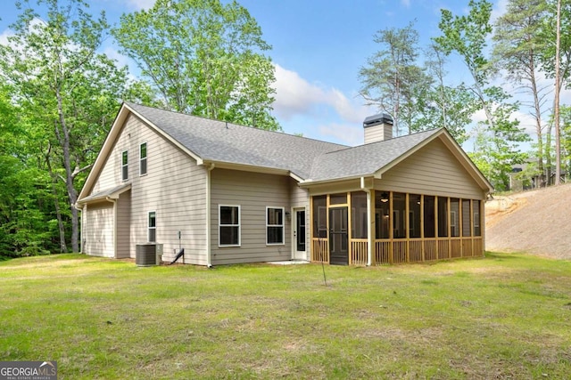 back of house featuring a lawn, a chimney, and a sunroom